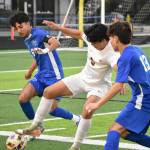 Ivan Floyd defends the ball from two Federal Way players. Ben Ray / The Mirror