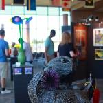 Flags designed by local youth hung from the ceiling above sculptures, paintings and much more at the annual arts explosion. This otter was created by a Federal Way artist. Photo by Keelin Everly-Lang / the Mirror.